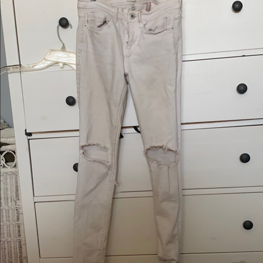 White low/mid waisted skinny jeans with knee slit